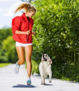 A woman running with a dog.